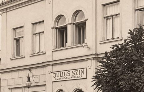 Gasthof zum Schilling mit Gastwirtschaft und Fleischhauerei – vor 1929 Gasthof zum Schilling in Lackenbach vor 1929 mit dem Schild von Julius Szin, mehreren Personen und Hunden vor dem Eingang